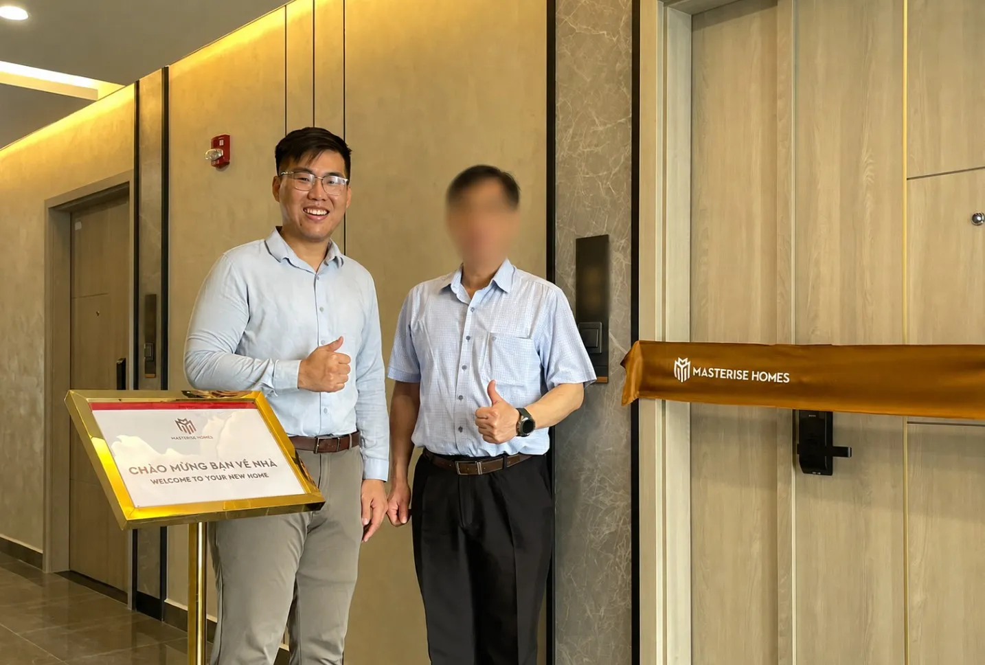 越富置產團隊陪同客戶於交屋現場，門前設有歡迎入住立牌