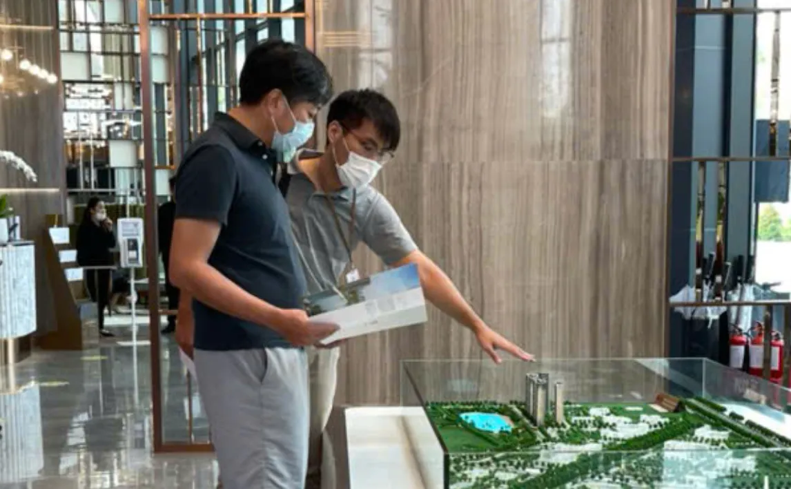 接待中心內團隊人員以建案模型向來訪者說明規劃